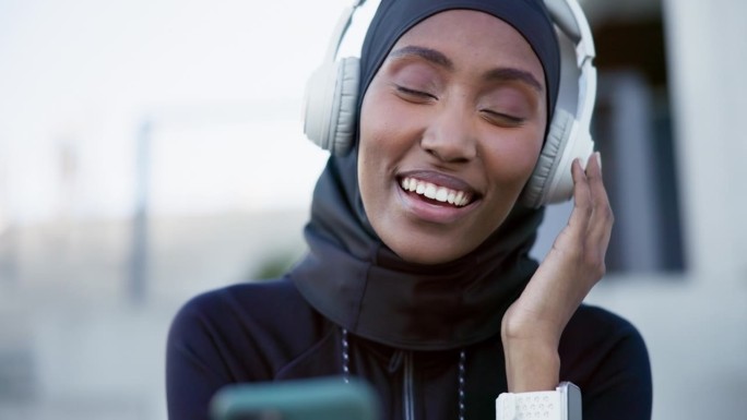 穆斯林，女人，戴着耳机听音乐，科技或流媒体广播，播客或在线音频自由。快乐，女孩戴着头巾，放松嘻哈，电