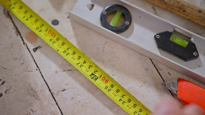 木工手在车库的工作台上用卷尺工作的特写镜头