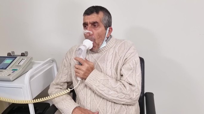 老人在医院做肺功能检查和肺活量测定。老年人用肺活量计测试呼吸功能