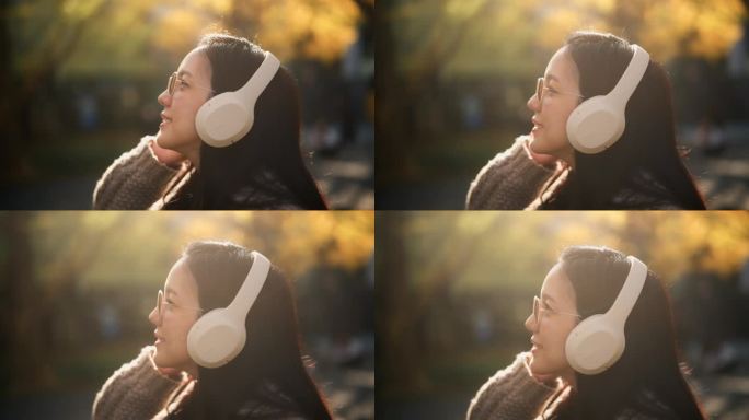 周末在公园里欢快的亚洲孕妇微笑着听音乐的特写。