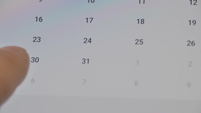智能手机的特写，手指滚动日历寻找正确的日期。确认会议或约会