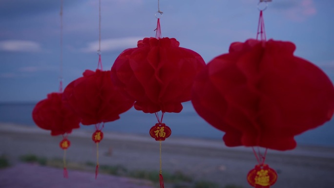 Chinese lanterns on beach near ocean at susnet