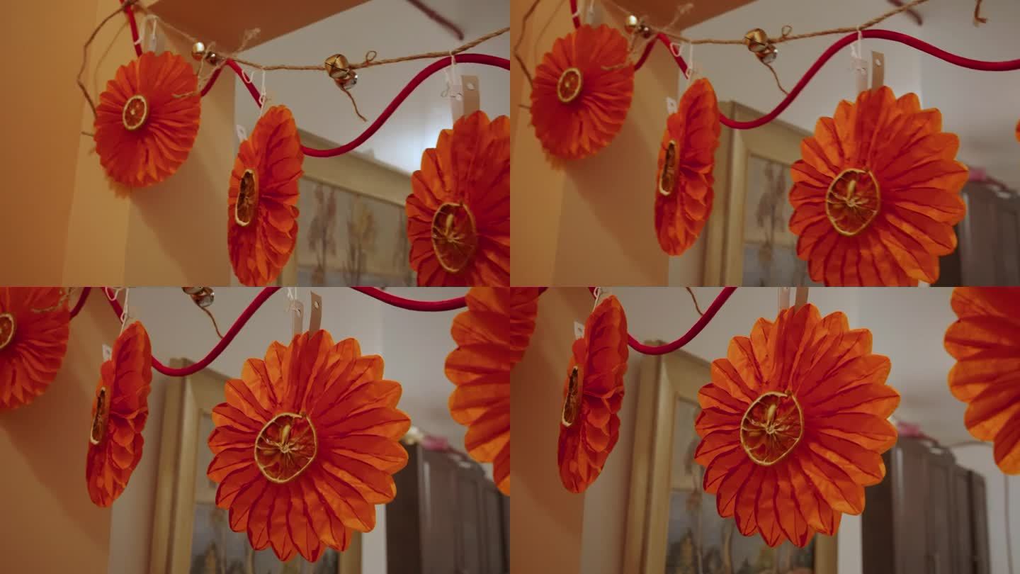 一串节日装饰品:铃铛，纸花，干橙子。
