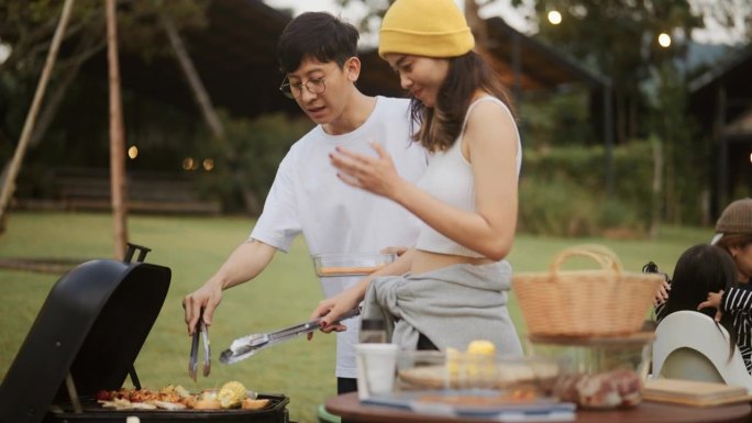 亚洲夫妇在户外烧烤食物，自然的氛围