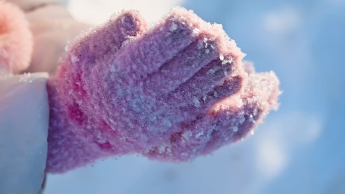 冬季阳光下儿童手捧雪花特写