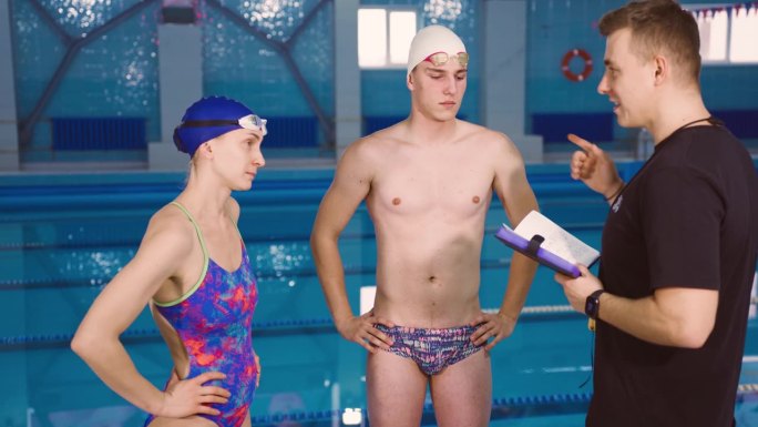 游泳池，教练激励和指导游泳运动员，并在锦标赛前解释训练计划。