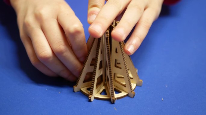 孩子们用单独的元素组装孩子们的木制构造器。
