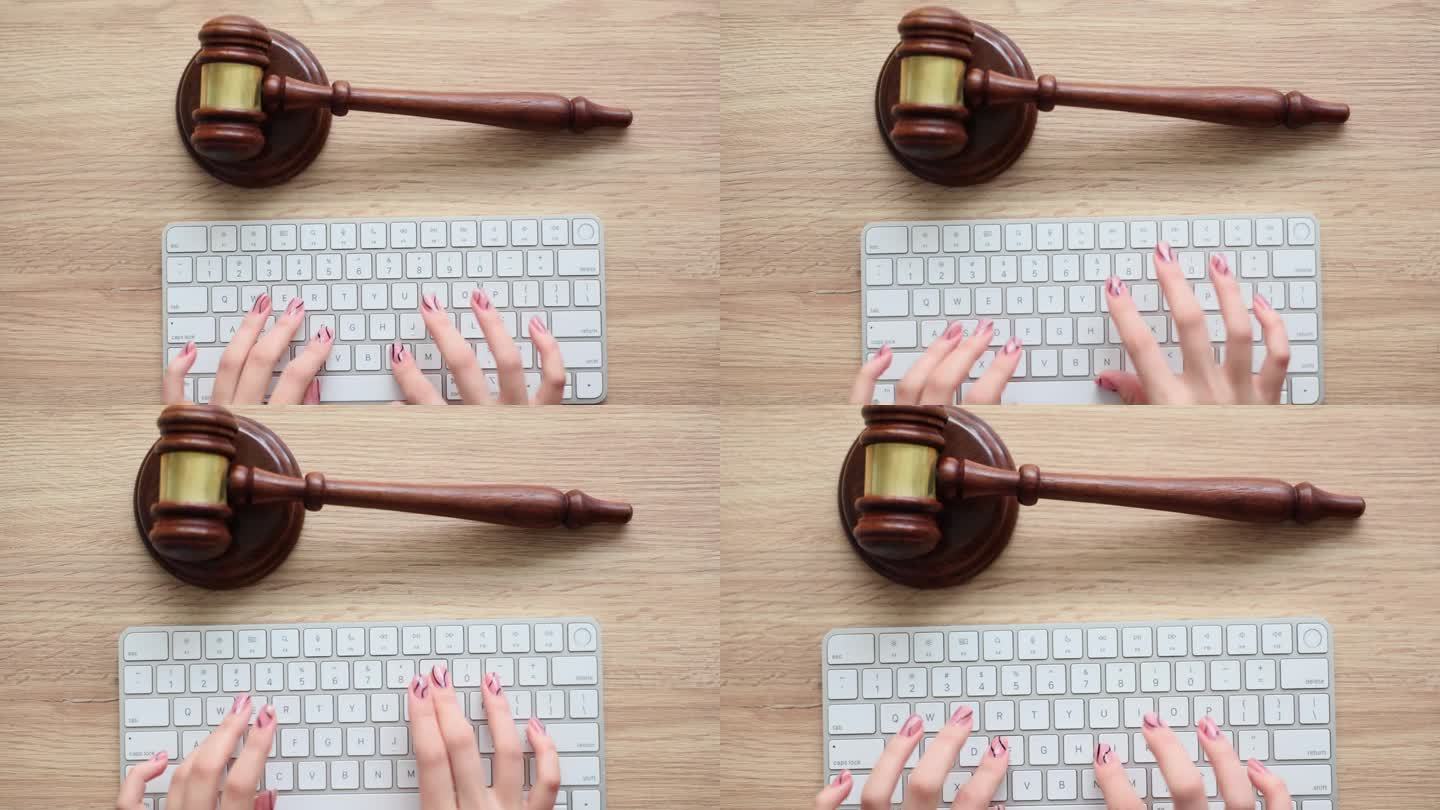 法官的手在木制桌面的电脑键盘上工作