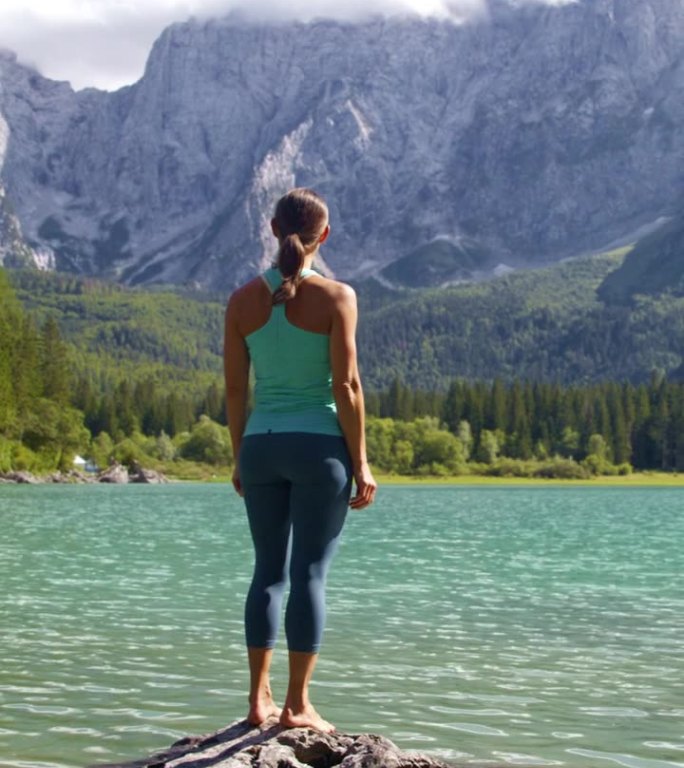 女徒步旅行者在落基山脉中欣赏湖泊美景的后视图