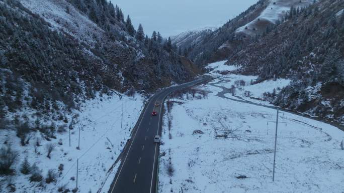 车辆行驶在下雪的山谷中