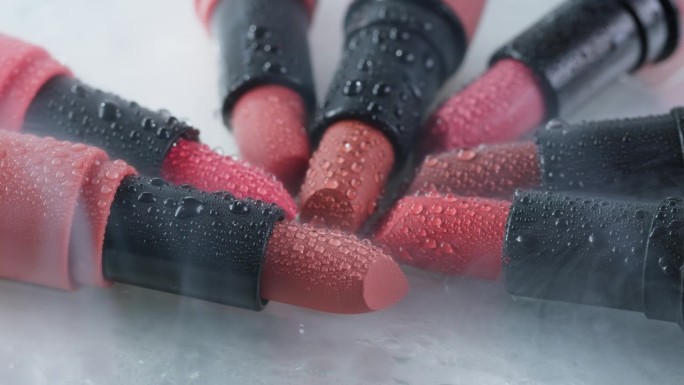 红色口红用烟雾和水滴构成特写背景，不同色调的粉色青铜色口红，工作室广告宏观美容理念。