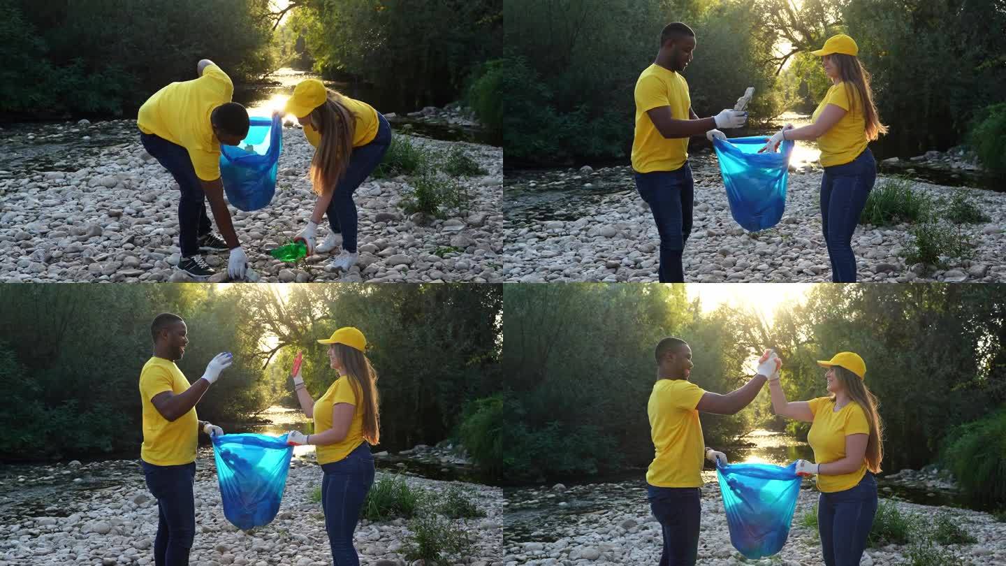 男志愿者和女志愿者在清理完河岸上的垃圾后握手