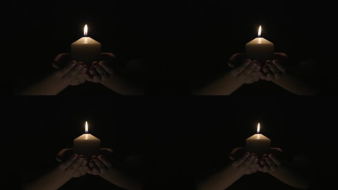 烛光指引生命，希望照亮，手握白烛的特写镜头，手握燃烧的白烛在黑暗中