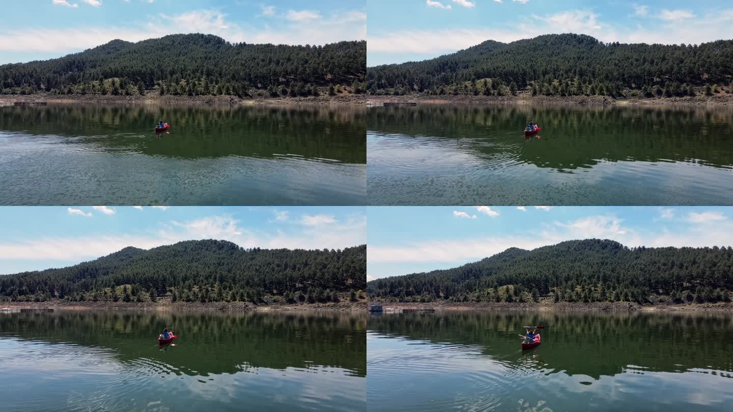 鸟瞰图，妇女和孩子在湖上与养鱼场划独木舟