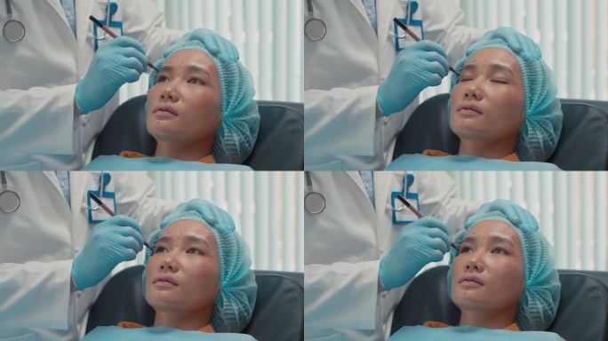 亚洲妇女躺在沙发上，整形医生在她脸上做记号