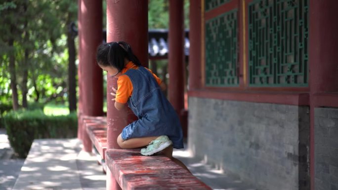 小女孩在中国风格的公园里玩耍