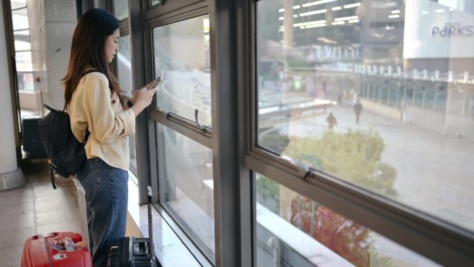 亚洲游客在日本机场用手机聊天机器人做生意