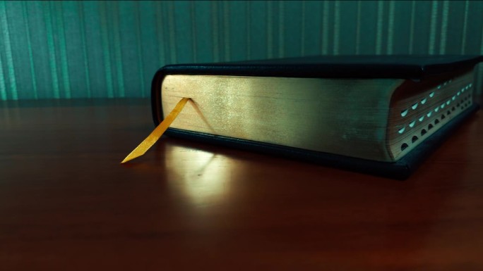 暗室里的桌子上放着一本镀金的古书。