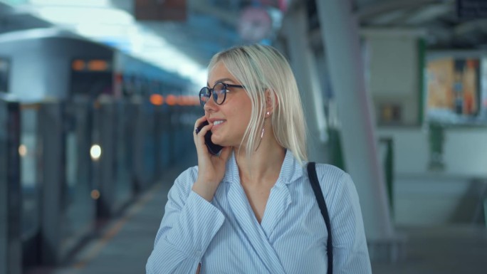 肖像，一个女人在地铁里打电话。商业上成功的女人在电话里微笑着笑着解决商业问题和同事朋友在电话里交谈。