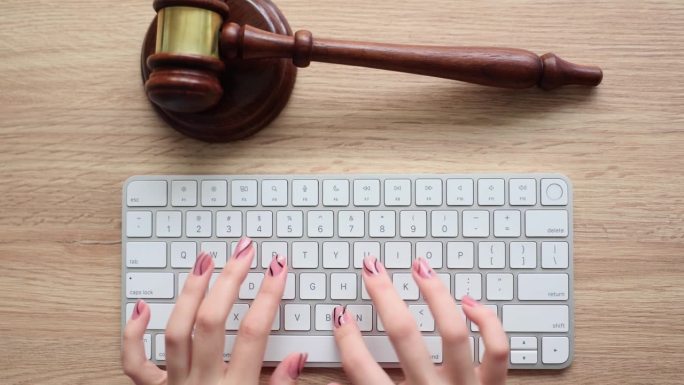 正义与法律观念与女法官在法庭上用木槌和电脑键盘工作