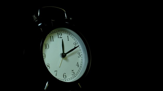 闹钟在黑色背景上，在延时视频的风格。