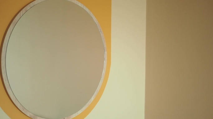 一面圆形的镜子挂在墙上。