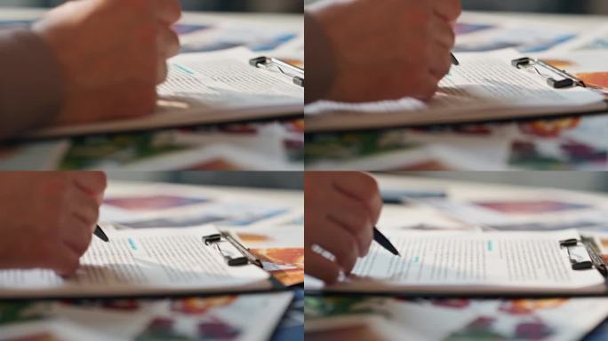 男子手握笔在桌子上检查合同。男子阅读协议