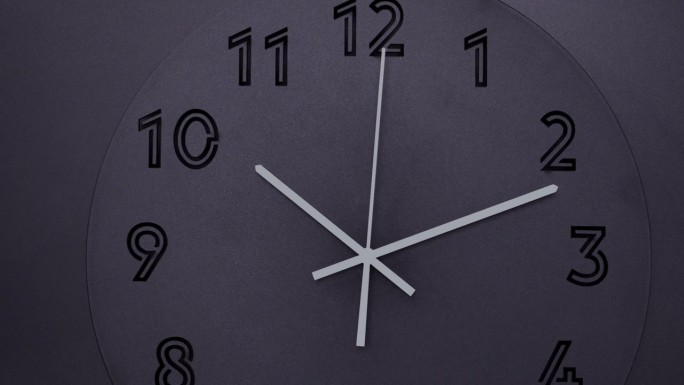 黑色挂钟在黑色背景上显示上午10点12分。