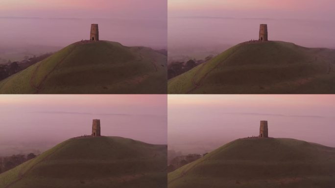 英国萨默塞特郡，格拉斯顿伯里岛朦胧的日出鸟瞰图，色彩斑斓的天空与背景中的乡村