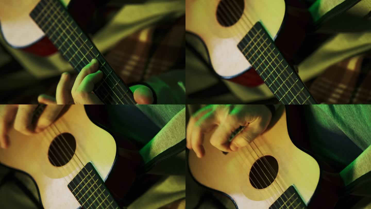 一个人手里拿着一把小尤克里里吉他，学着弹它。特写，绿色大气光