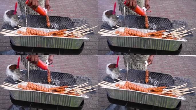 在巴拿马的街头烧烤:令人垂涎欲滴的美食串在烤架上。厨师把香肠放在一只即将上市的猪上。