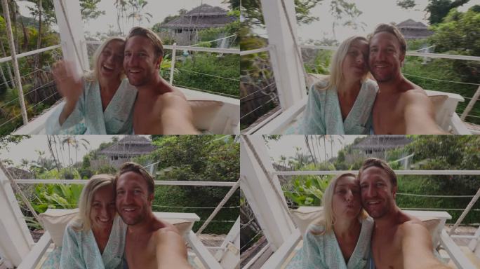 度假的年轻夫妇在酒店房间的吊椅上摇摆自拍，看到了热带雨林的景色