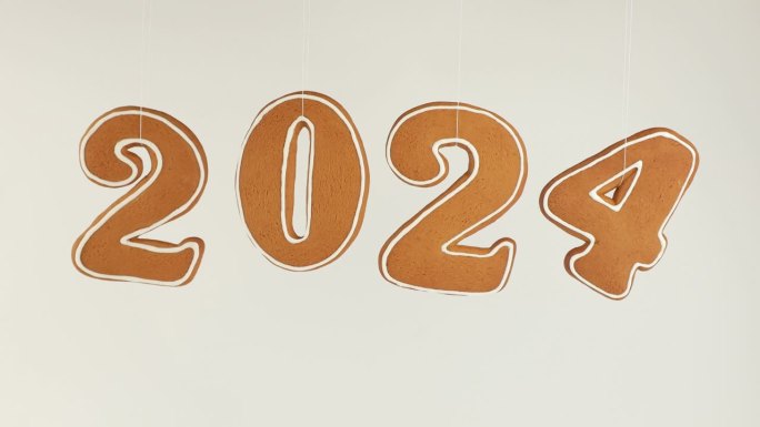 这一年是2024年。摇摆的数字2024是在白色背景上用姜饼面团烤出来的。姜饼。