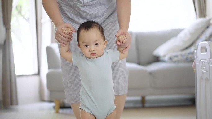 母亲在家里训练儿子学走路