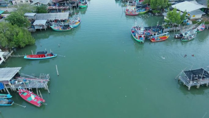 无人机飞过这条河口河流，展示了这个渔村，船只和人们从上面看到游泳，邦普渔村，Sam Roi Yot国