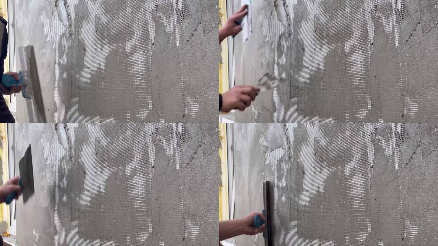 用油漆抹刀手工抹墙的特写。外墙补强网在墙体保温后铺设。