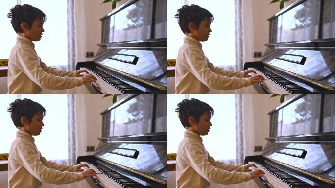 英俊的少年钢琴家弹奏着三角钢琴，用手指触摸着黑白键
