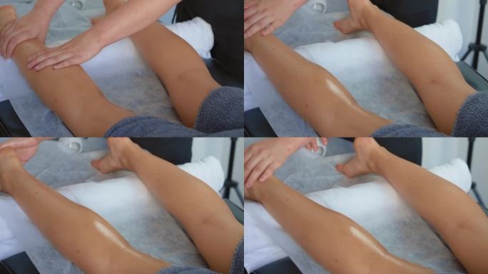 一名年轻女子在度假水疗沙龙用油按摩腿部和脚部。女子在豪华水疗中心接受全身按摩
