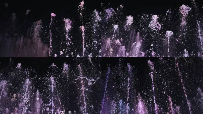 夜间喷泉溅起的水花被拍摄成慢动作，并用冷光照亮。