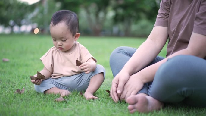 母亲带着男婴在公园户外玩耍