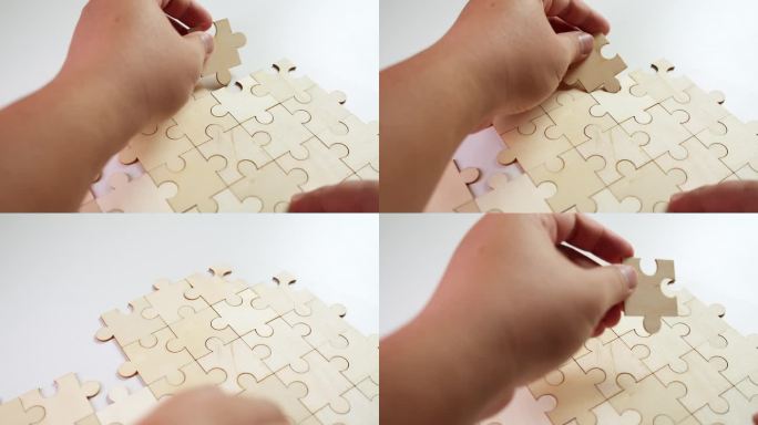 一个人试着解决一个没有图片的拼图，右手握住碎片，而右手一个接一个地添加。