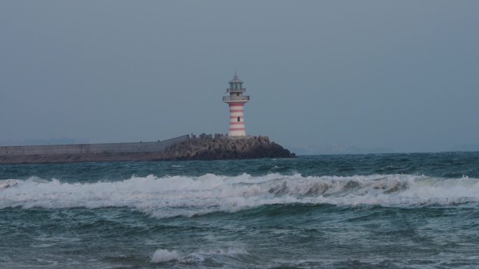 4k阴天海边灯塔海浪消失的她