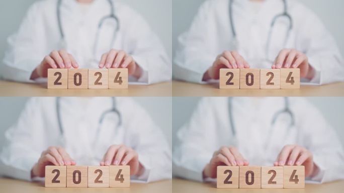 医生的手在2023到2024街区翻转。祝医疗、保健、保险和健康理念新年快乐