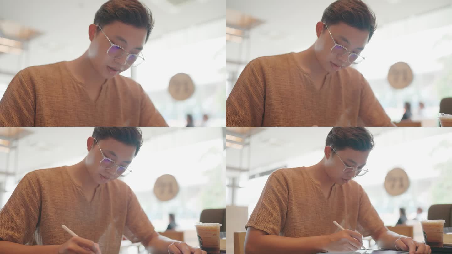 时尚男士在咖啡店喝茶拿着平板电脑在笔记本上写字在咖啡店，工作或学习。