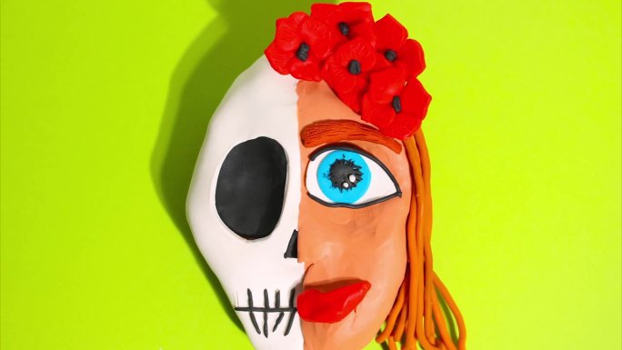 定格动画。一个女人的橡皮泥头被分成头骨，另一边是带着红色王冠的花头发。蓝眼睛的女孩。