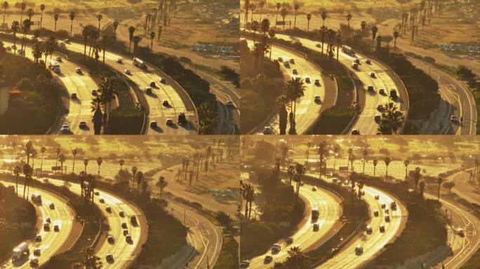 日出时高速公路高峰时段的高角度视图。车辆通过多车道公路的急转弯。美国加州文图拉
