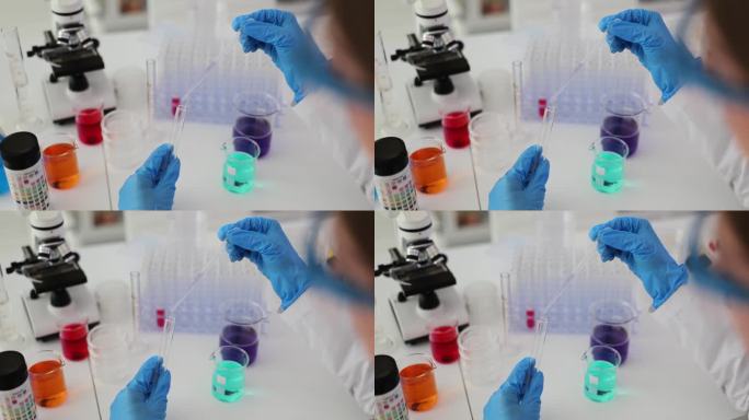 实验室科学家用移液管分析一种清澈的液体，将DNA和分子提取到试管中