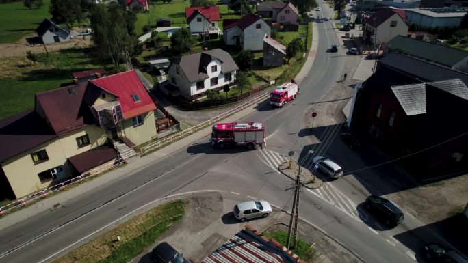 4k无人机拍摄的消防车在农村十字路口在晴朗的一天