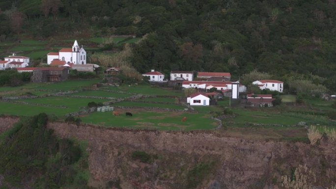 亚速尔群岛弗洛雷斯岛小镇上白色教堂的侧面平移镜头