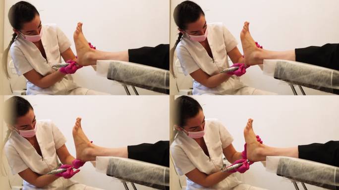 足疗专家，医学面膜制作足部足疗。在水疗沙龙接受古典五金足疗的女人的腿。腿部和指甲皮肤护理。水疗过程